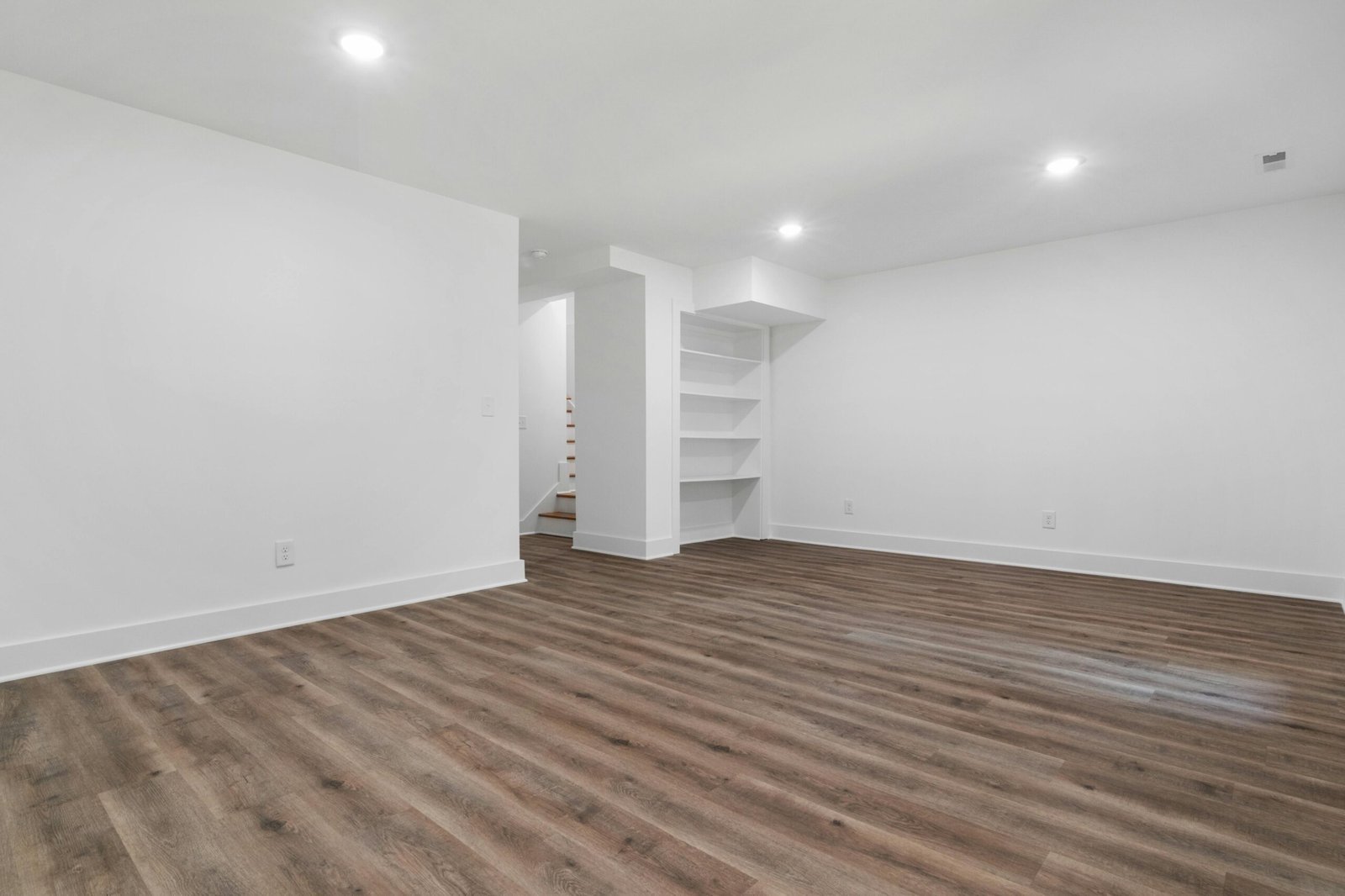 Bright finished basement with pot lights and open living layout