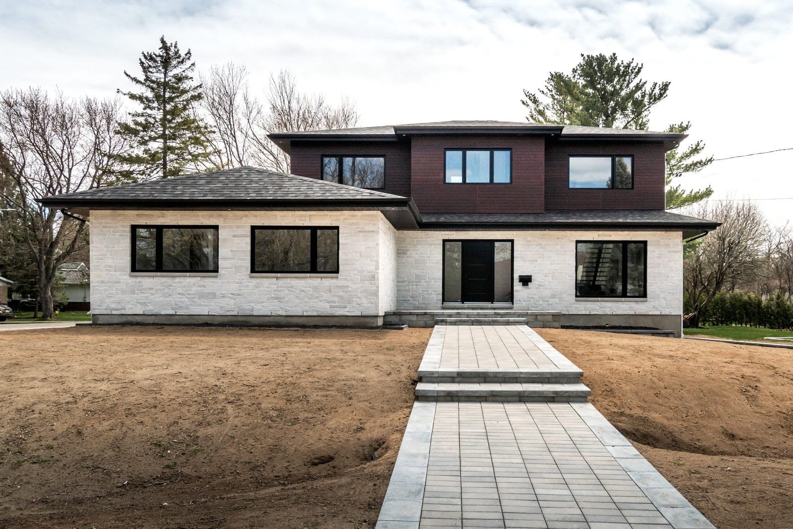 New custom built home with modern exterior and stone walkway