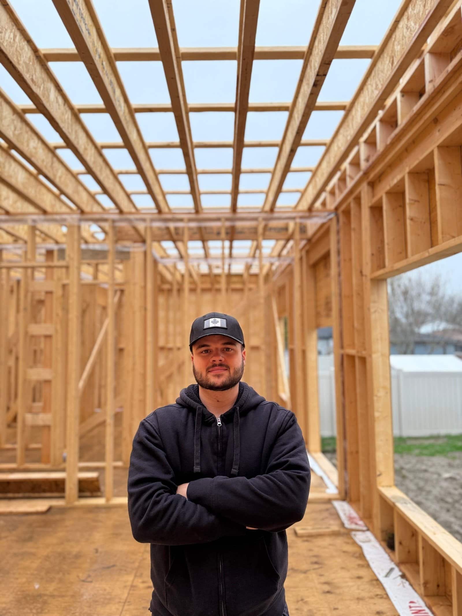 Mauro, owner of Aloe Contracting, standing inside a custom home frame in Barrie, Ontario